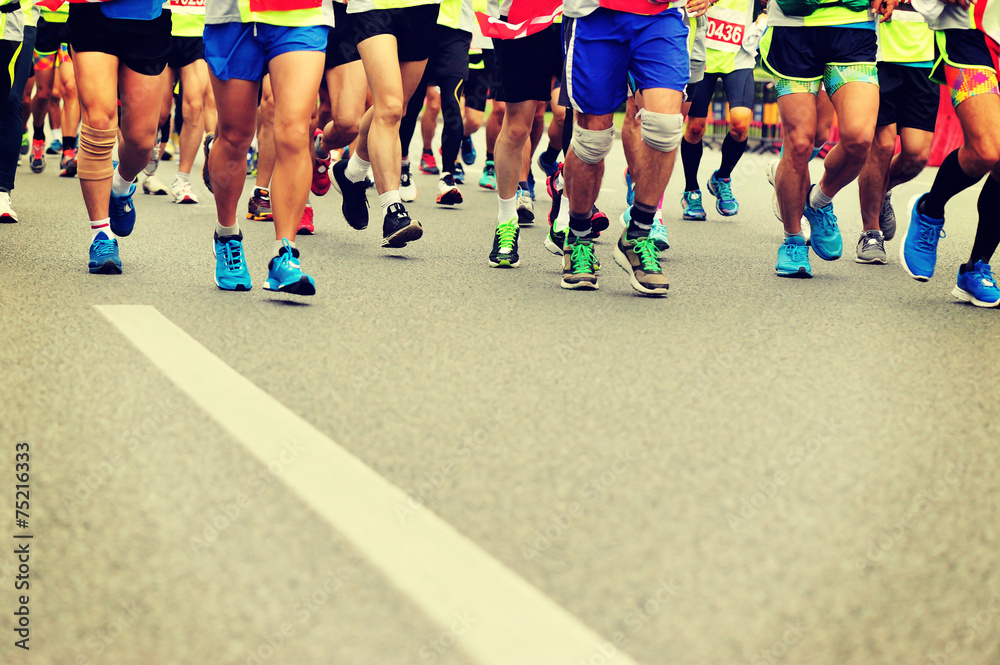 marathon athletes legs running on city road marathon athletes legs running on city road