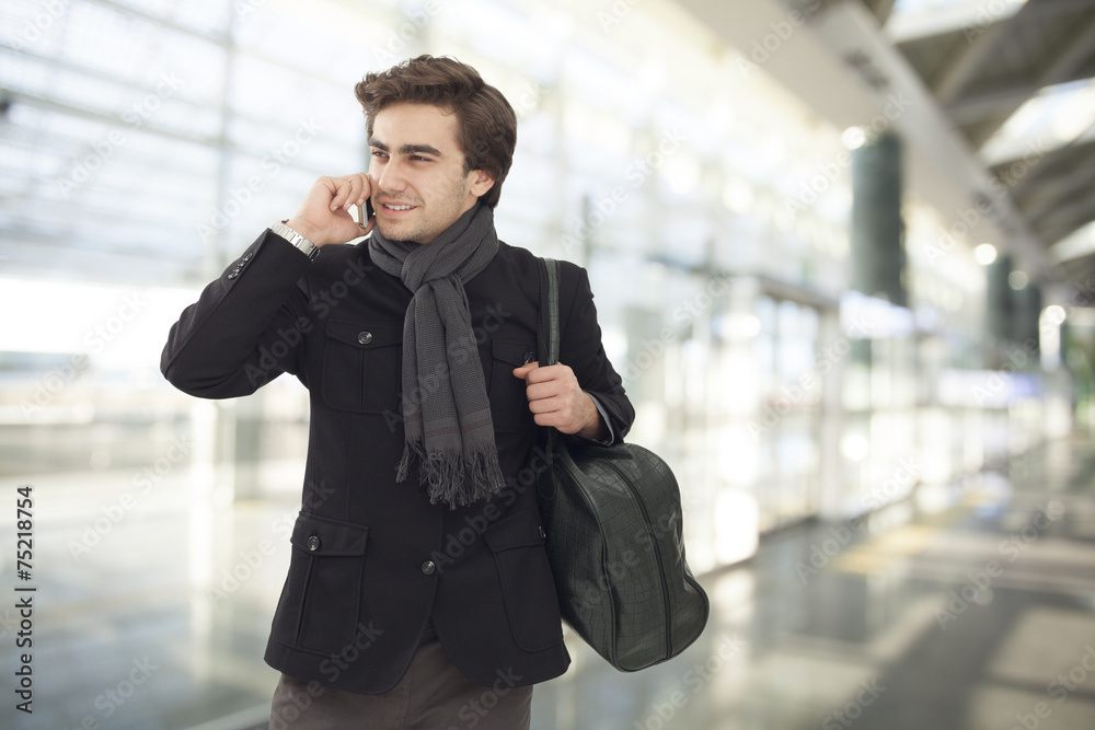 Young businessman talking on mobile phone in airport Young businessman talking on mobile phone in airport