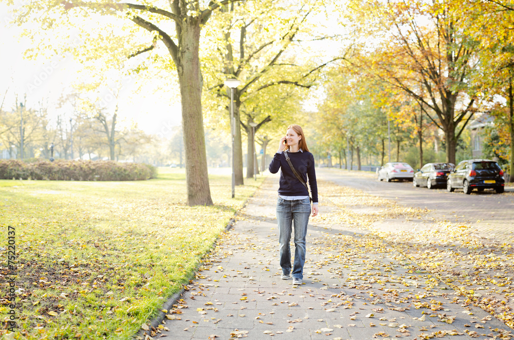 Woman Walking in Park and Calling by Phone