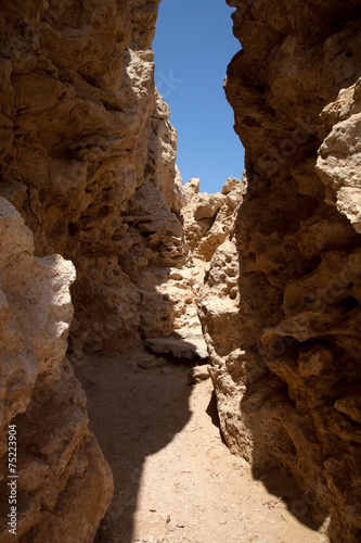 Crevice in the rock, forming a tunnel. tinted