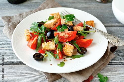 salad with tomatoes and croutons on a white plate