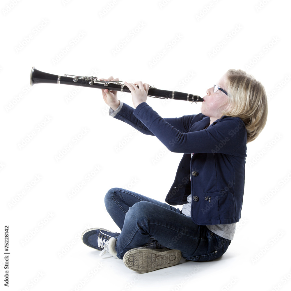 young blond girl in blue plays clarinet in studio