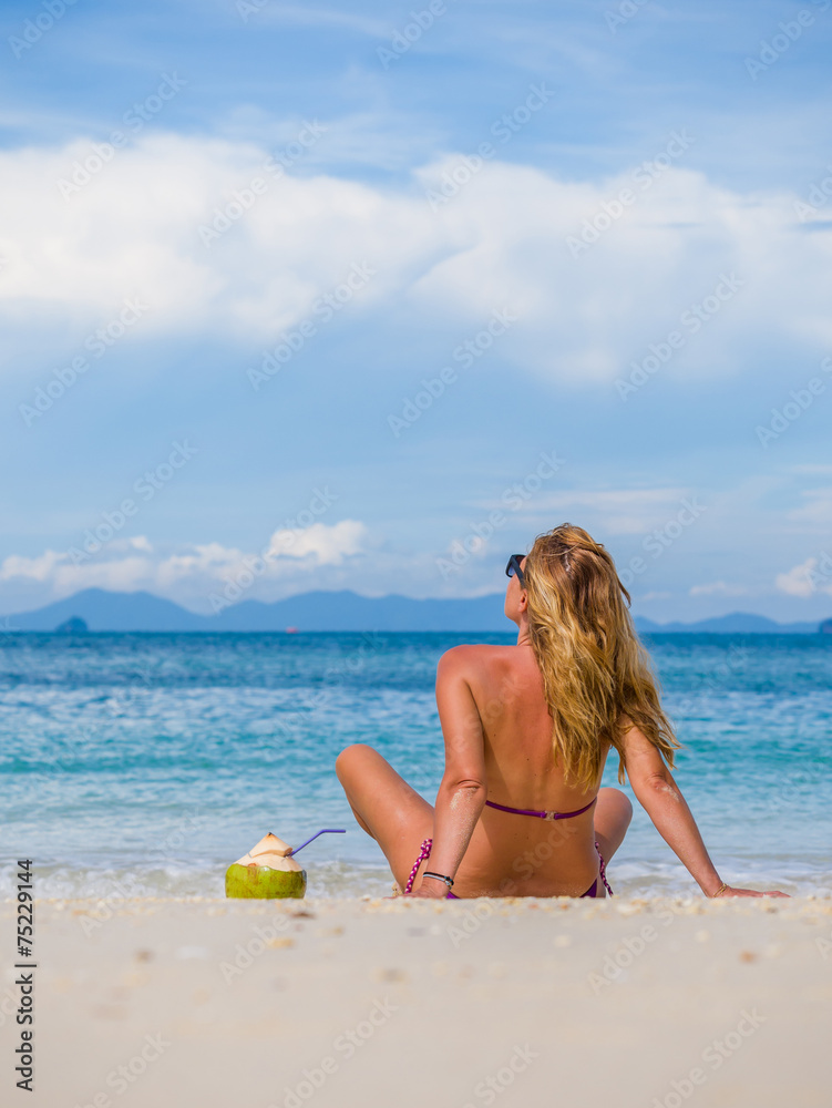 Naklejka premium Woman on the beach with coconut drink