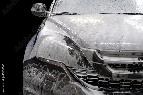 Modern car covered by foam. Car wash.