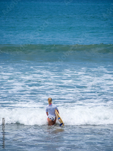 Beautiful young woman surfing in Kuta © Netfalls