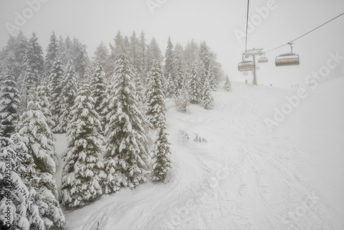 Chairlift in snowfall at alpine ski resort