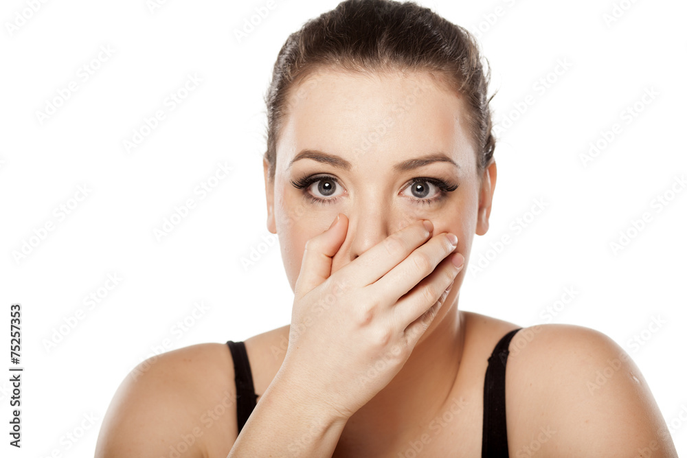 surprised young woman covering her mouth with her hand surprised young woman covering her mouth with her hand