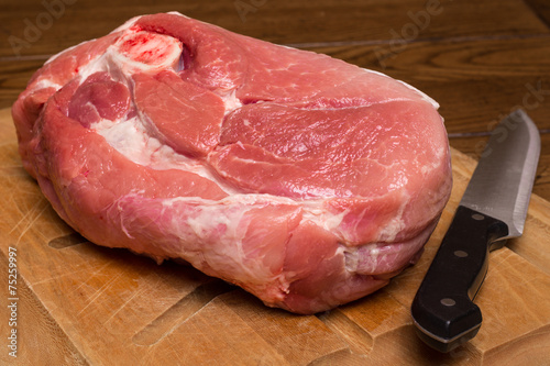 Canvas Print Raw cut of pork shoulder on cutting board with knife