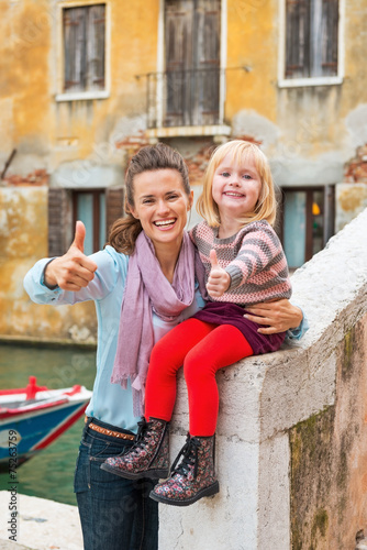 Happy mother and baby girl showing thumbs up in venice, italy