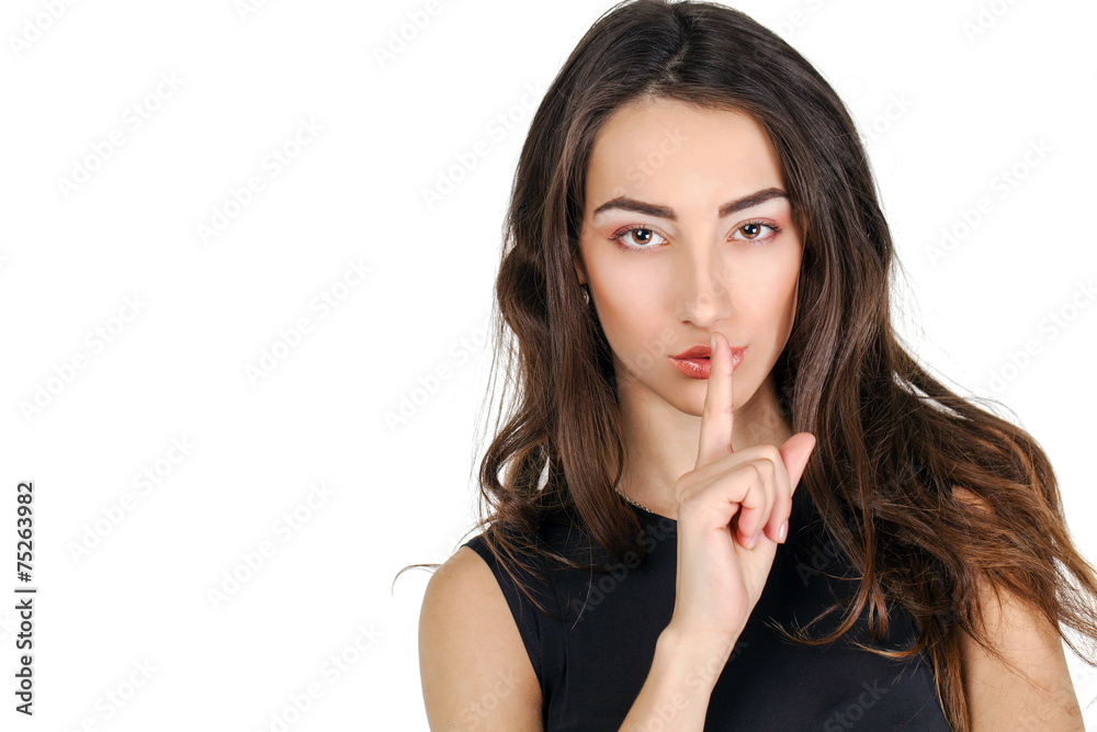 Woman has put forefinger to lips as sign of silence Woman has put forefinger to lips as sign of silence
