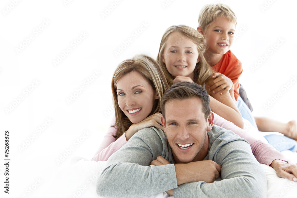 Portrait of a happy young family with two children doing a human pyramid