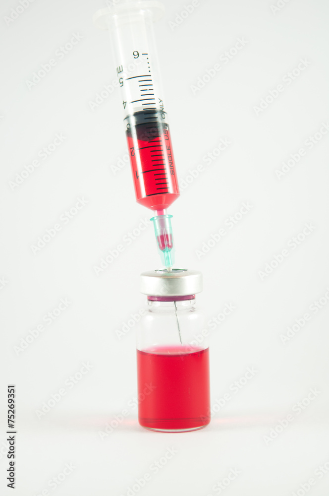 Red liquid in injection syringe and vials background Red liquid in injection syringe and vials background