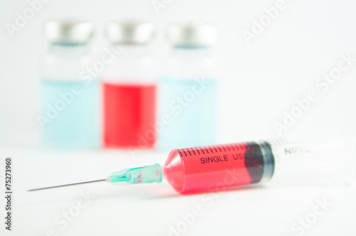 Red liquid in injection syringe and vials