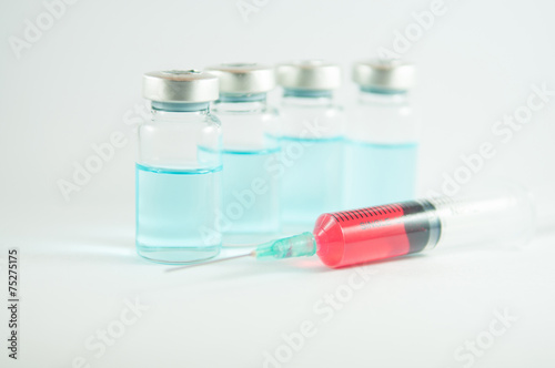 Red liquid in injection syringe and vials