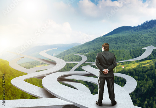 Businessman stands choosing his way