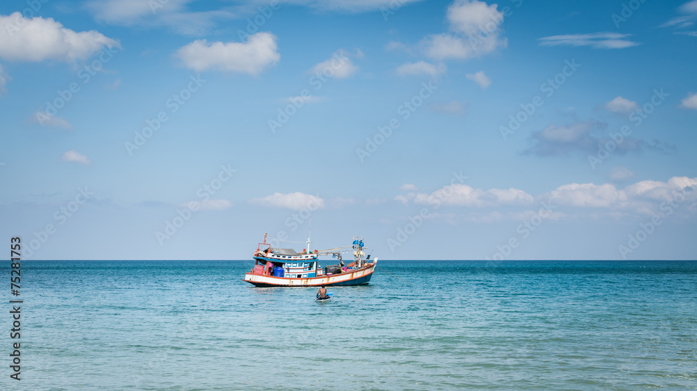 Fisherman with his fishing boat on the sea