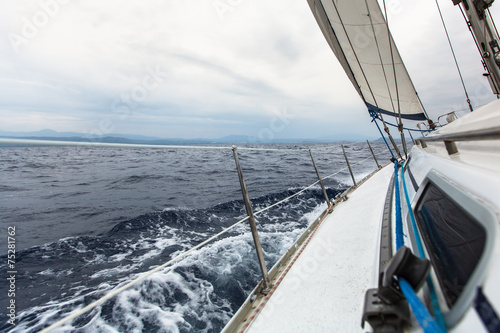 Sailing yacht on the race in a stormy sea.