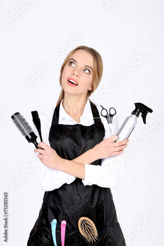 Beautiful girl hairdresser on light background