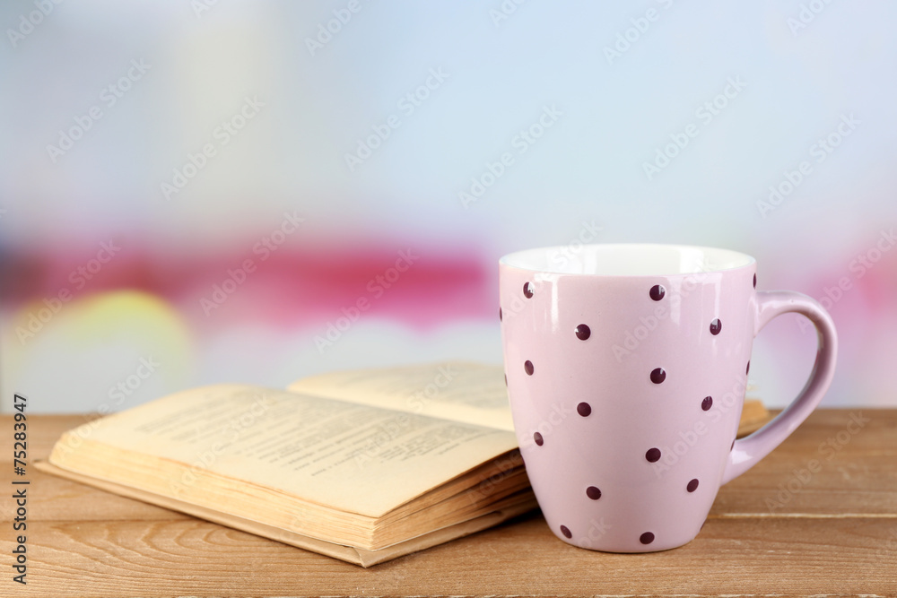 Cup of tea and book on table, on bright background Cup of tea and book on table, on bright background