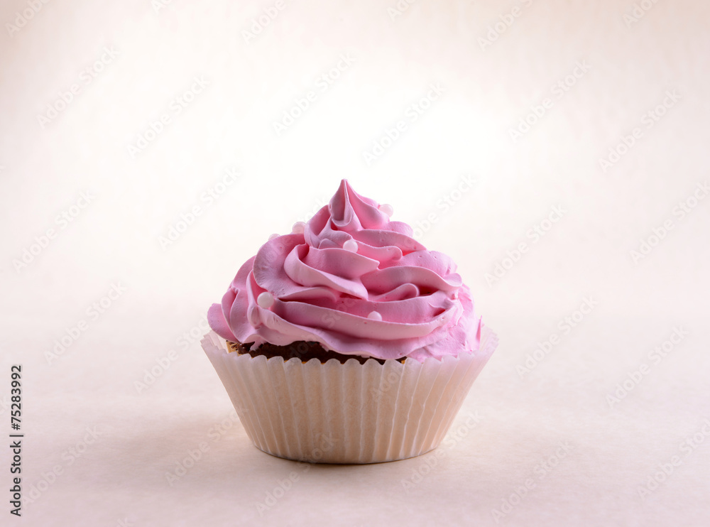 Delicious cupcake with inscription on table on beige background Delicious cupcake with inscription on table on beige background
