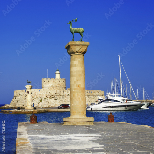 Rhodes Mandraki harbor with castle and deer statues, Greece
