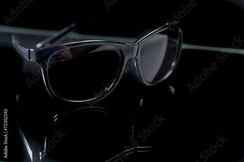 Closeup of Shiny Modern Fashion Sunglasses On Reflecting Surface