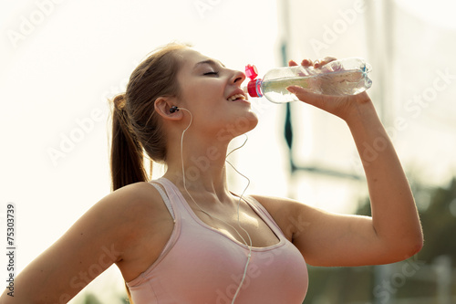 Fotografie beautiful woman drinking water after running at hot day