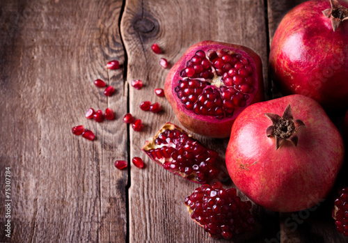 Some red pomegranates on old wooden table