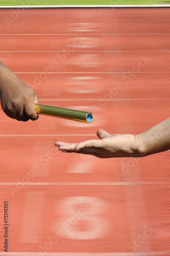  Relay-athletes hands sending action on blur race track  startin photo