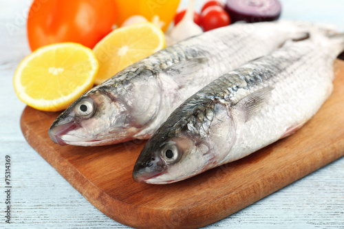 Fresh raw fish and food ingredients on table