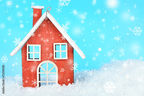 Christmas decoration in shape house on light blue background