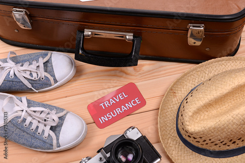 Suitcase and tourist stuff with inscription travel insurance