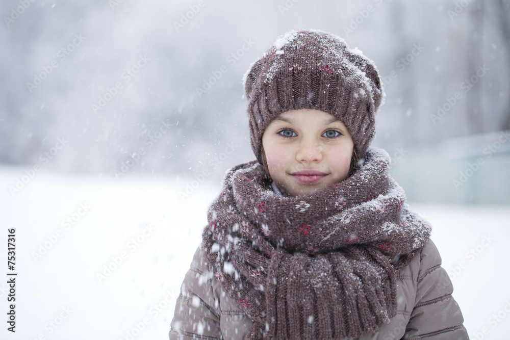 Portrait of a happy little girl on the background of a winter pa Portrait of a happy little girl on the background of a winter pa