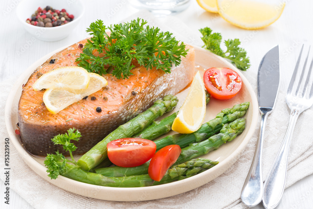 baked salmon with asparagus, parsley and lemon on plate baked salmon with asparagus, parsley and lemon on plate