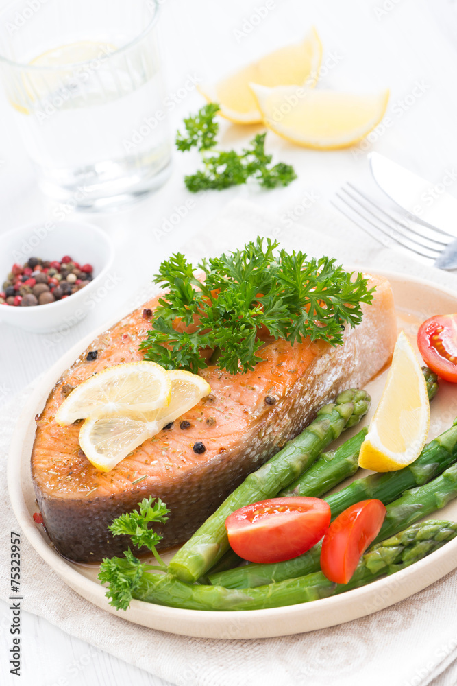baked salmon with asparagus, parsley and lemon, top view