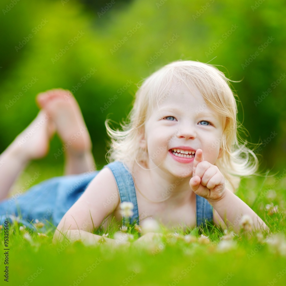 Cute little toddler girl laying in the grass Cute little toddler girl laying in the grass