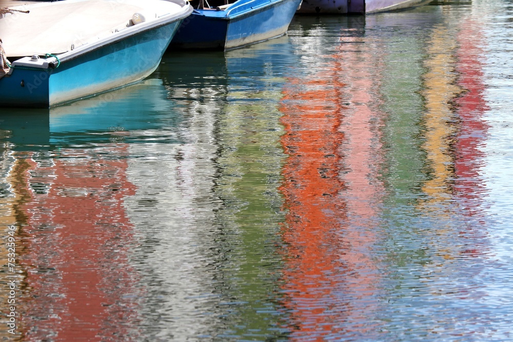 Colorful houses on BURANO island reflected on the water and some