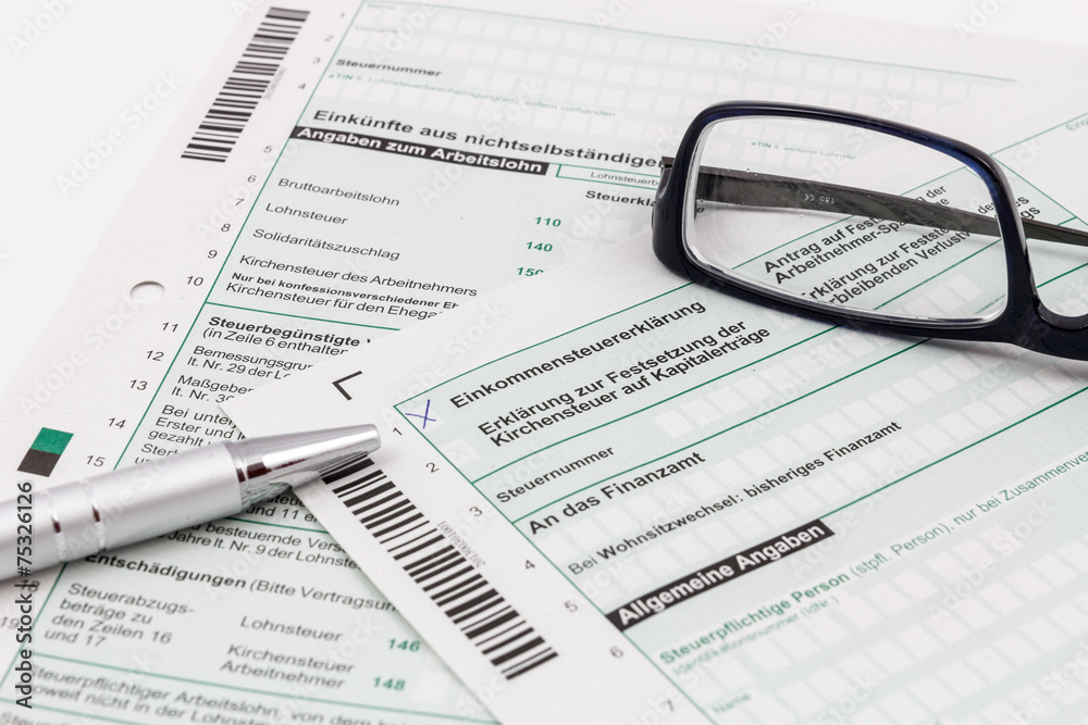 Formular Einkommensteuererklärung mit Kugelschreiber und Brille Formular Einkommensteuererklärung mit Kugelschreiber und Brille