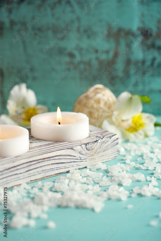 Candles, bottles sea salt and spa stones on wooden background