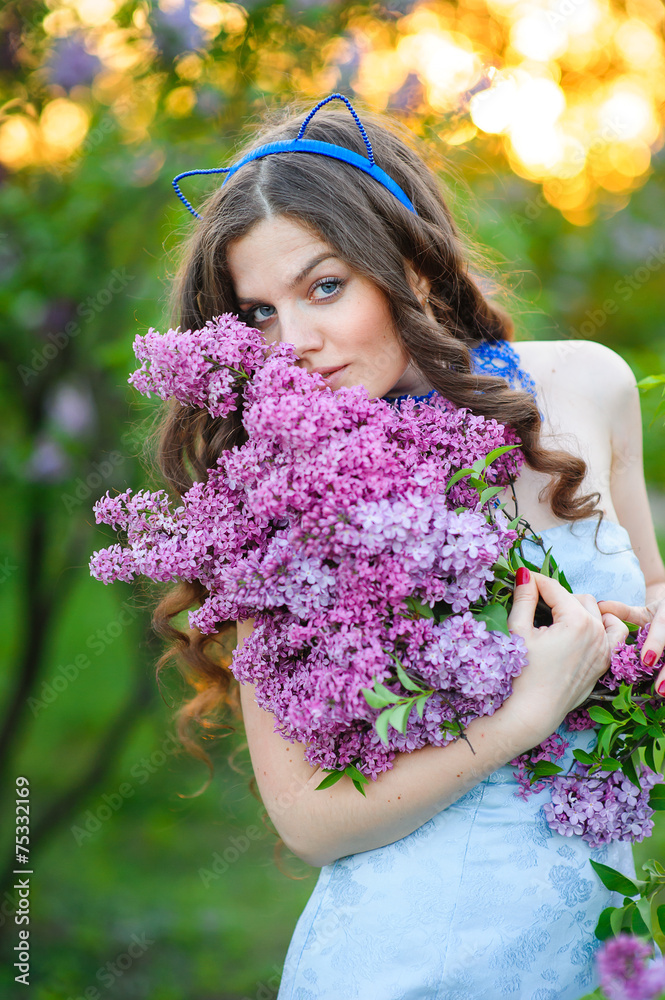 Fototapeta premium beautiful woman with a bouquet of lilacs in the spring