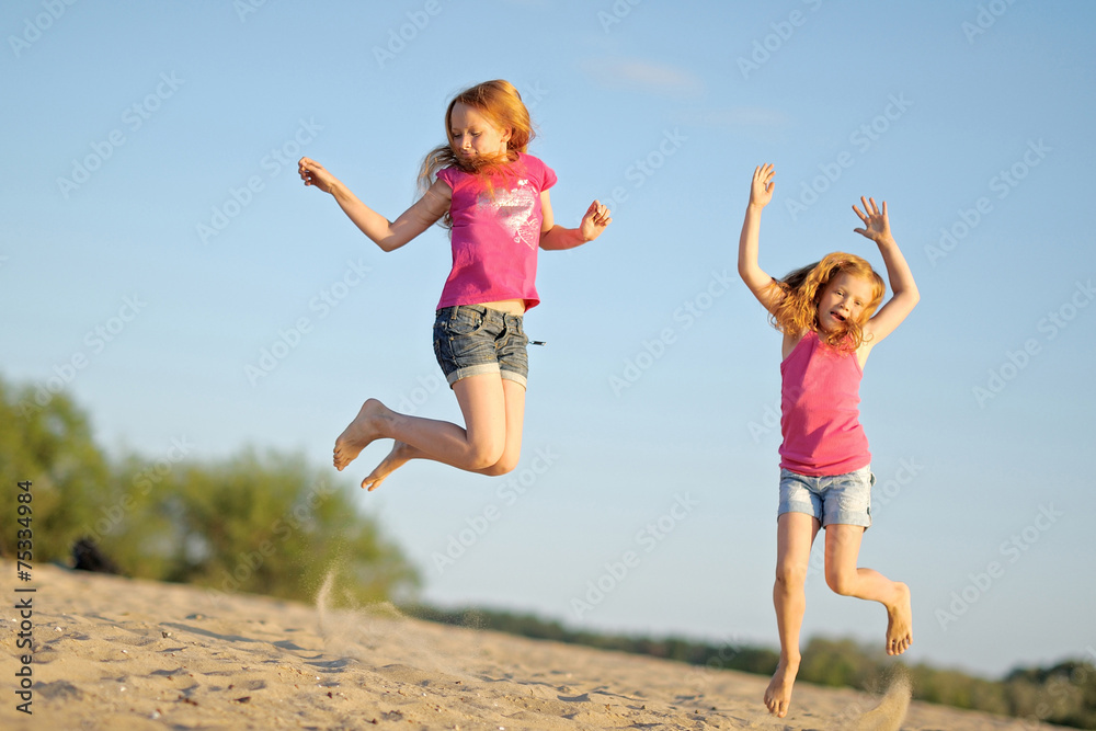 portrait of two sisters walking on the beach portrait of two sisters walking on the beach