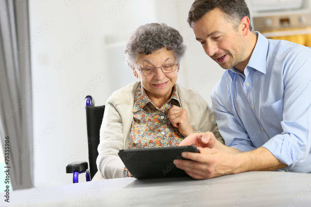 Man with elderly woman using digital tablet Man with elderly woman using digital tablet