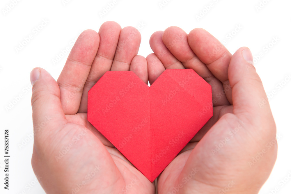 Fototapeta premium hands holding an origami heart