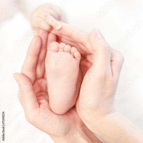 baby foot in mother's hands with care © Andrey Kuzmin