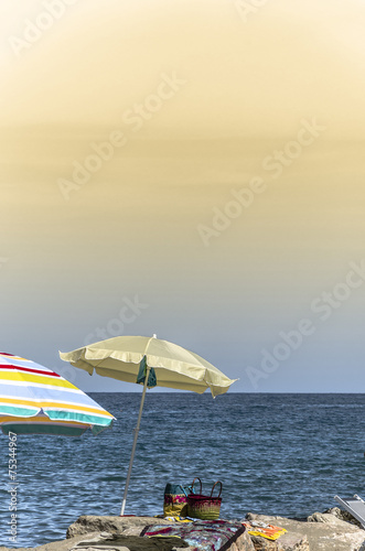 Ombrelloni al mare sugli scogli © giadophoto