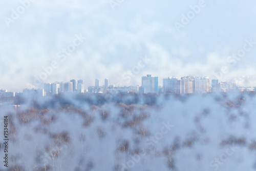 view of urban houses through snow-covered window