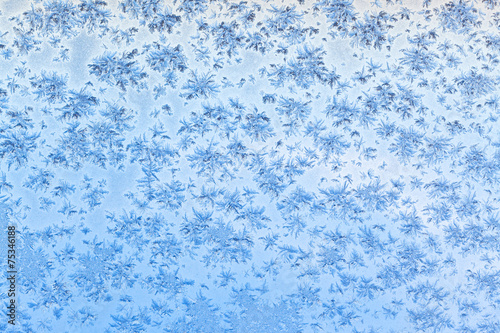 snowflakes and frost on window with blue sky