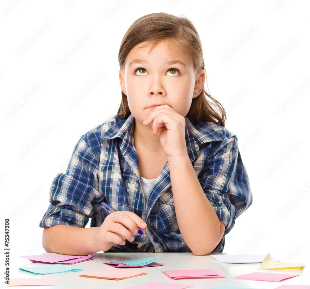 Girl is writing on color stickers using pen Girl is writing on color stickers using pen