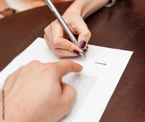 Hands of two people signed the document