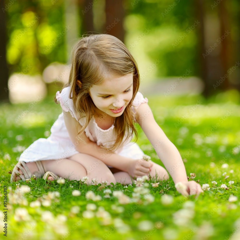 Cute little girl sitting on a clover field Cute little girl sitting on a clover field